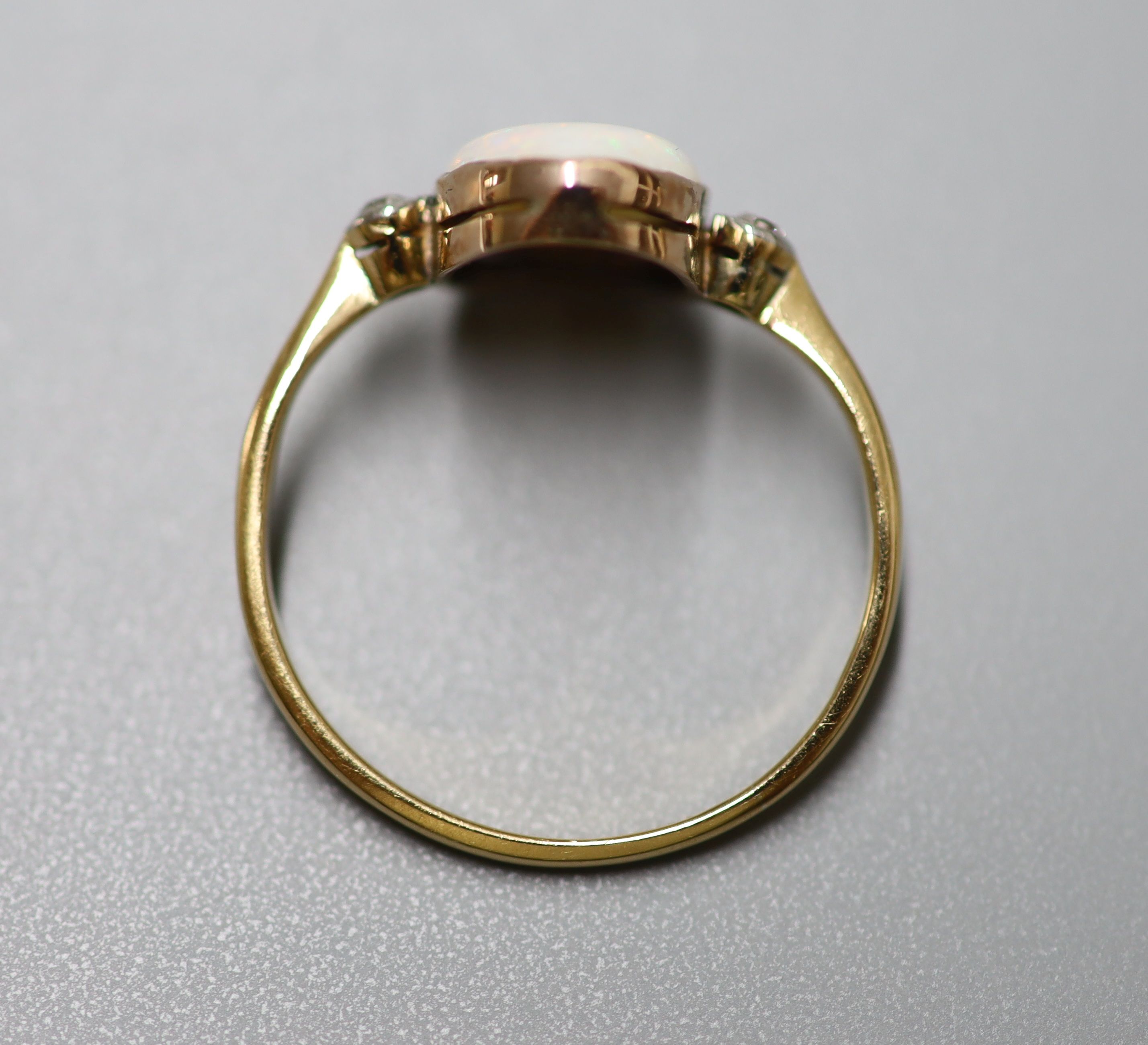 An 18ct, white opal and two stone diamond set oval ring, size O/P, gross 1.7 grams.